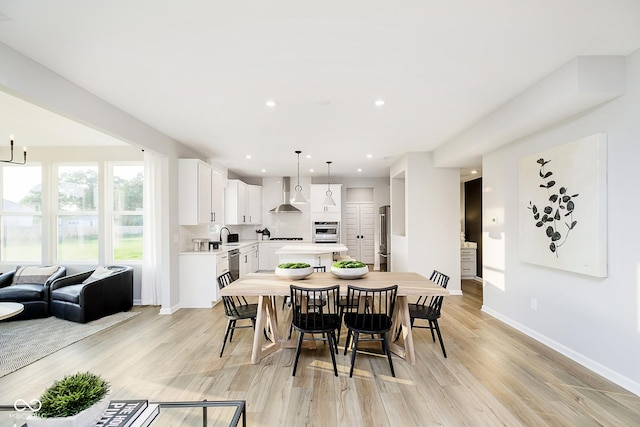 dining room with recessed lighting, light wood-type flooring, and baseboards