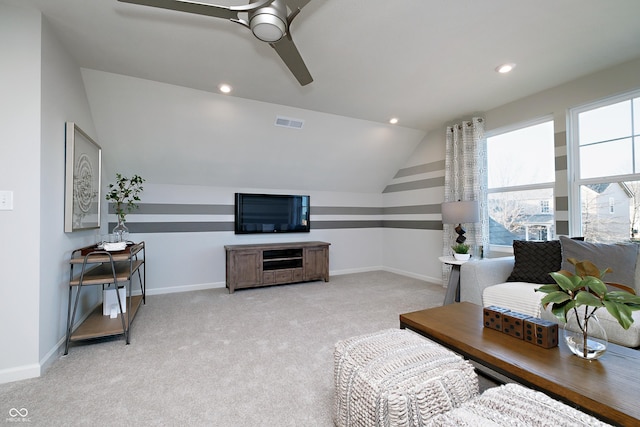 living room with light colored carpet, visible vents, a ceiling fan, vaulted ceiling, and baseboards