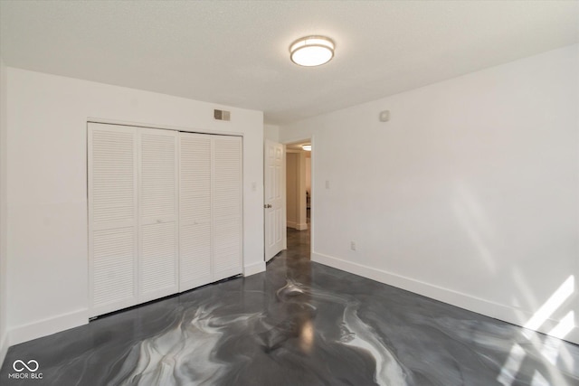 bedroom featuring baseboards, visible vents, a textured ceiling, concrete floors, and a closet