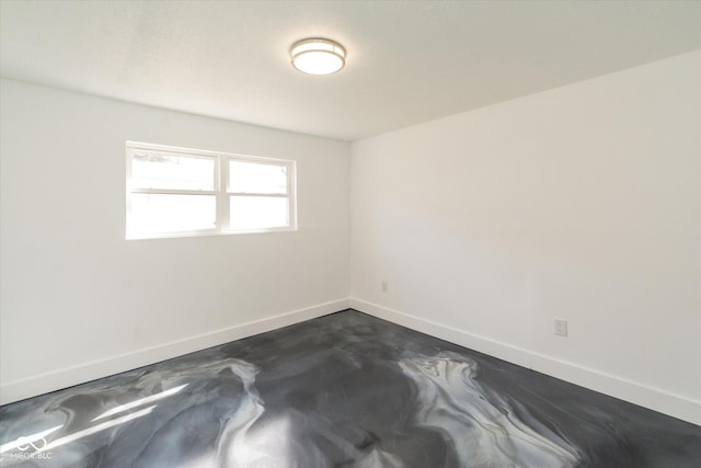 spare room with concrete floors and baseboards