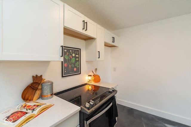 kitchen with concrete flooring, electric range, white cabinetry, baseboards, and light countertops