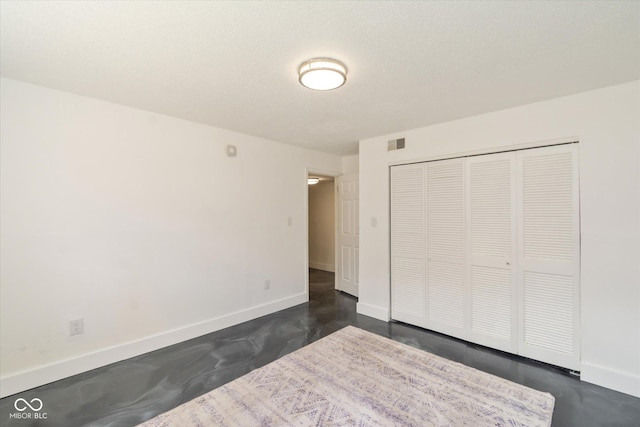 unfurnished bedroom featuring baseboards, finished concrete floors, and visible vents