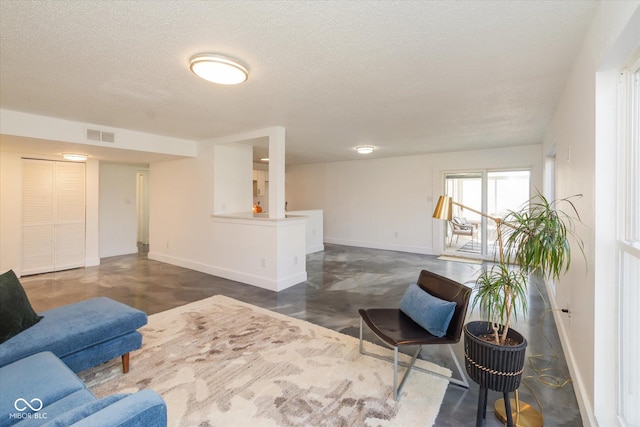 living area with visible vents, a textured ceiling, and baseboards