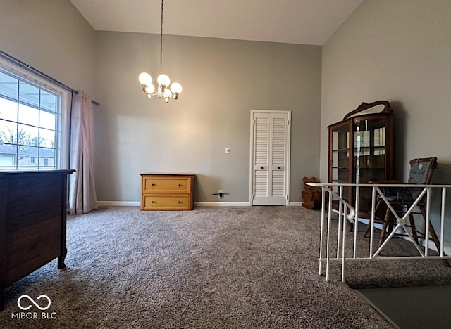 unfurnished bedroom featuring a chandelier, carpet floors, a towering ceiling, and baseboards