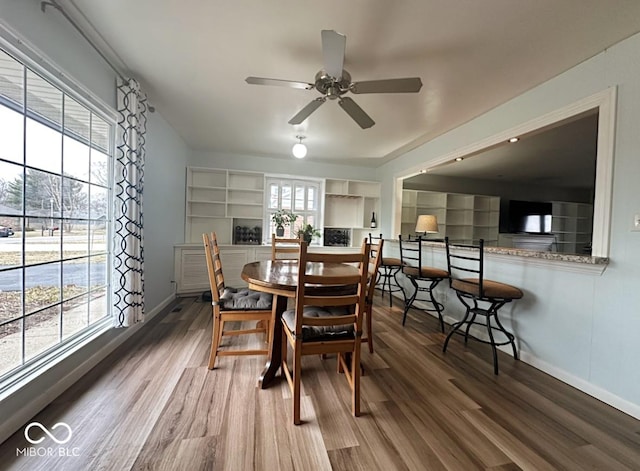 dining area with ceiling fan, plenty of natural light, wood finished floors, and baseboards