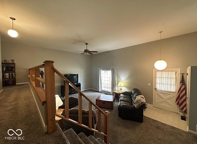 carpeted living room featuring stairway, ceiling fan, and baseboards