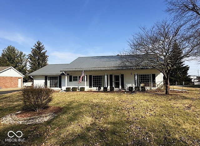 view of front of home featuring metal roof, a porch, and a front lawn