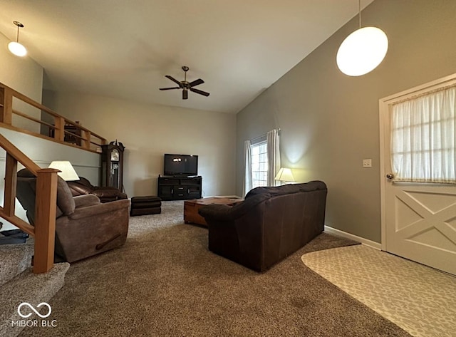 carpeted living room with a ceiling fan, a high ceiling, and baseboards