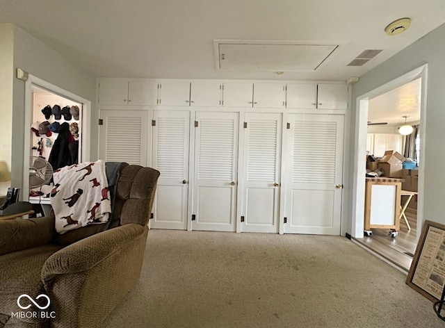 sitting room with carpet floors, attic access, and visible vents