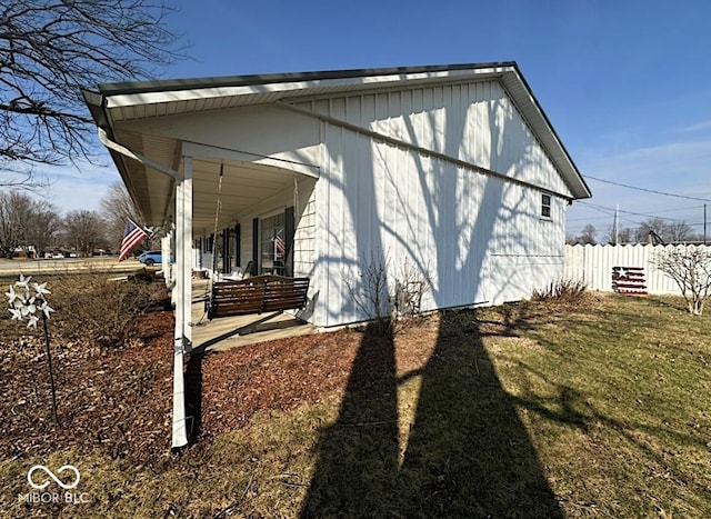 view of home's exterior featuring covered porch, a yard, and fence