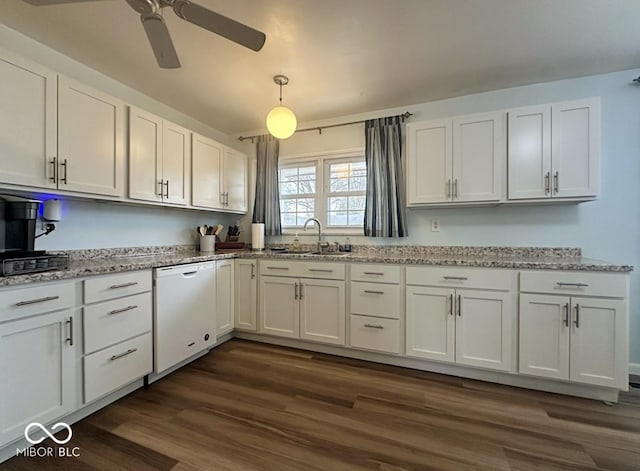 kitchen with white dishwasher, dark wood-type flooring, a sink, white cabinets, and light stone countertops