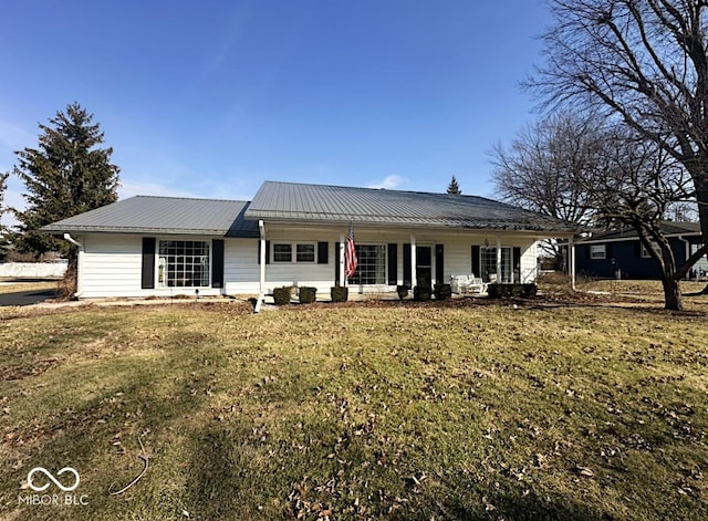 back of house with a yard, covered porch, and metal roof