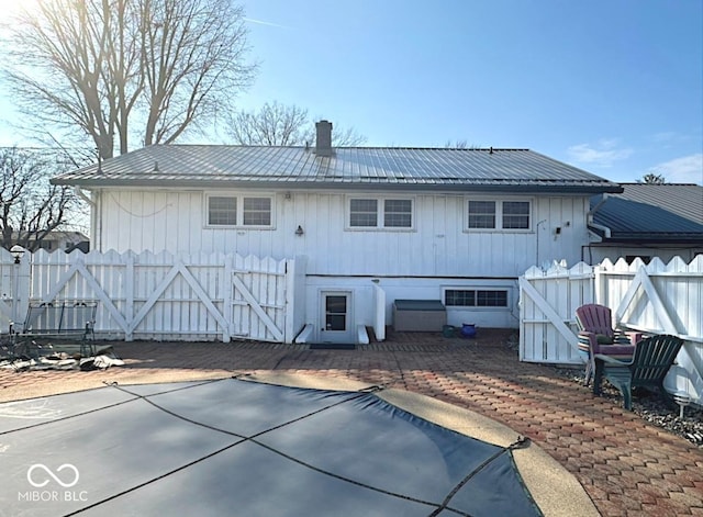 1406 Durham Dr, Crawfordsville, IN 47933 - rear view of property with metal roof, a patio, a chimney, and fence