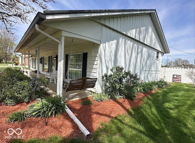 1406 Durham Dr, Crawfordsville, IN 47933 - view of home's exterior featuring board and batten siding, covered porch, a lawn, and fence