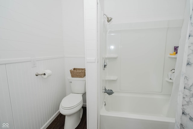 full bath featuring shower / bath combo with shower curtain, a wainscoted wall, toilet, and wood finished floors