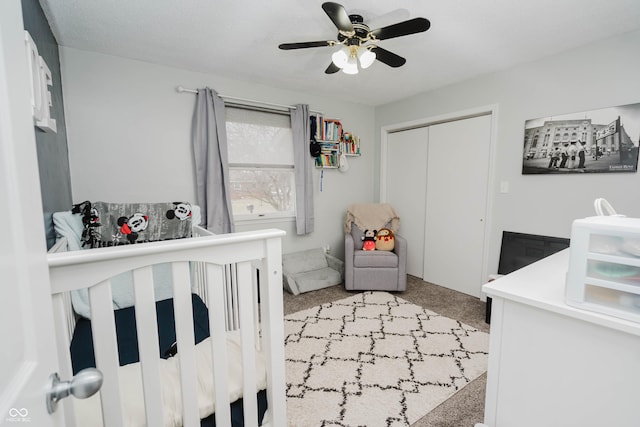 bedroom featuring a ceiling fan, a closet, and light colored carpet