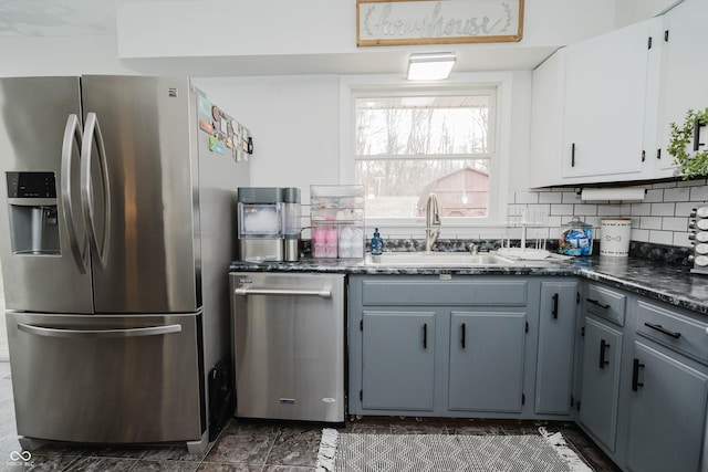 kitchen with a sink, white cabinetry, appliances with stainless steel finishes, gray cabinets, and decorative backsplash