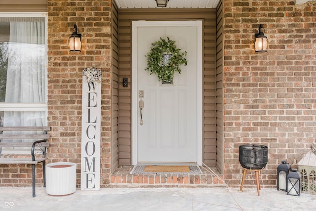 entrance to property featuring brick siding