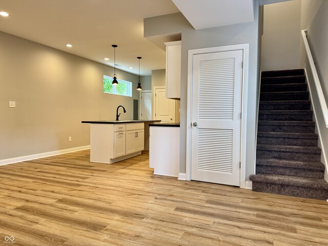 857 N Oakland Ave, Indianapolis, IN 46201 - kitchen featuring dark countertops, light wood-style floors, recessed lighting, white cabinetry, and a sink