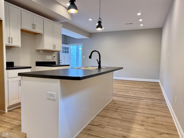 857 N Oakland Ave, Indianapolis, IN 46201 - kitchen with a sink, dark countertops, white cabinets, light wood-style floors, and recessed lighting