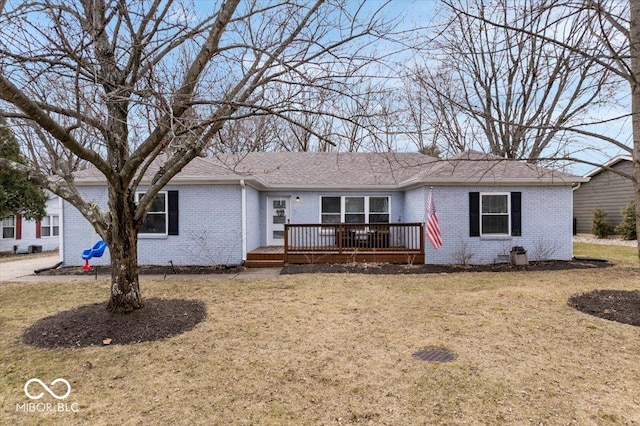 ranch-style home with a wooden deck, a front lawn, and brick siding