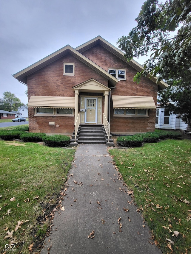 view of front facade with brick siding and a front yard