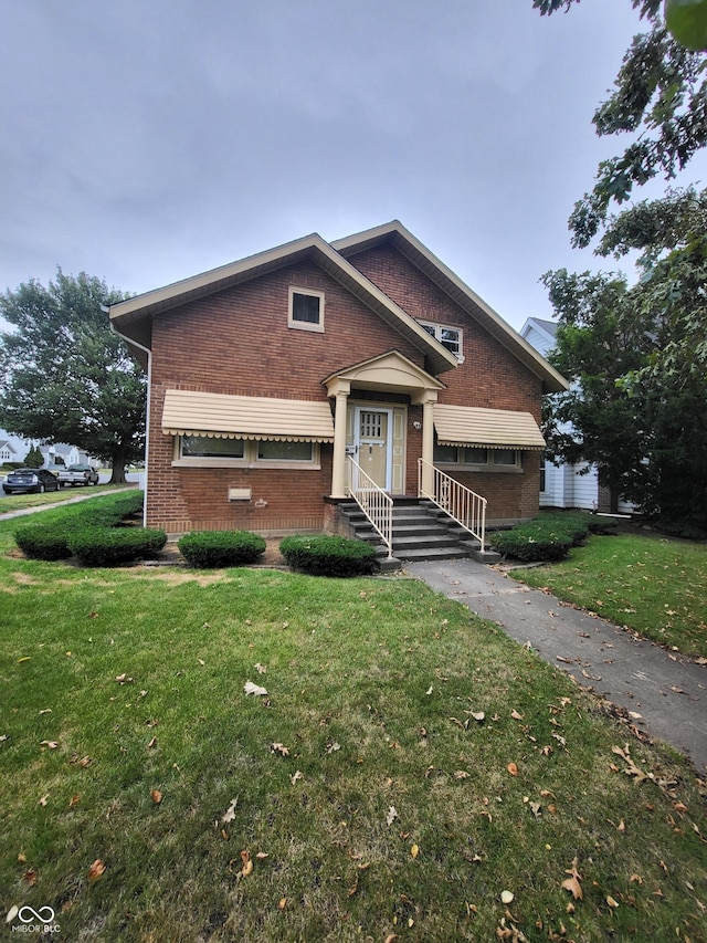 view of front facade with brick siding and a front yard