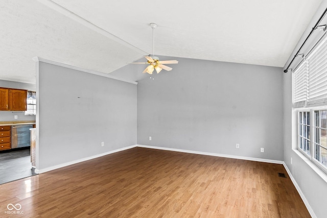 unfurnished living room featuring dark wood-style floors, visible vents, vaulted ceiling, ceiling fan, and baseboards