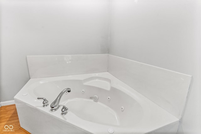 bathroom featuring a whirlpool tub and wood finished floors