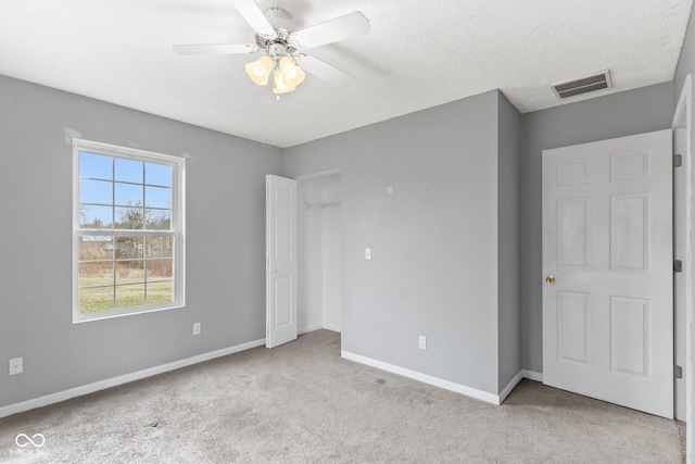 unfurnished bedroom with visible vents, a ceiling fan, carpet flooring, a textured ceiling, and baseboards