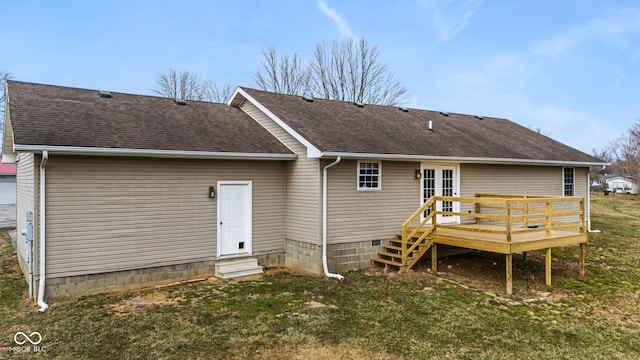 back of property with a shingled roof, entry steps, a lawn, and a deck