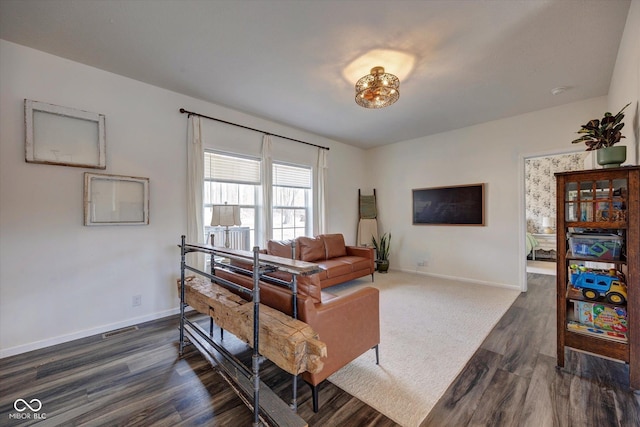 living room with dark wood-type flooring, visible vents, and baseboards