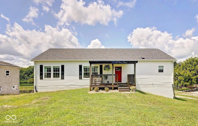 single story home featuring a porch, roof with shingles, and a front yard