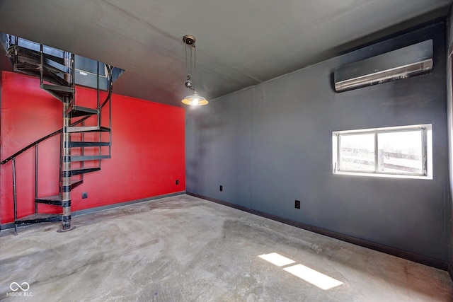 unfurnished room featuring stairway, baseboards, unfinished concrete flooring, and a wall mounted air conditioner