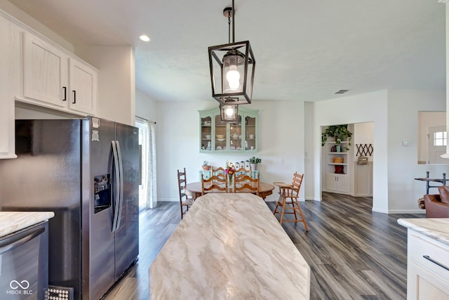 kitchen with appliances with stainless steel finishes, dark wood finished floors, glass insert cabinets, and baseboards