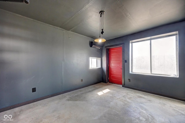 empty room with unfinished concrete flooring and baseboards