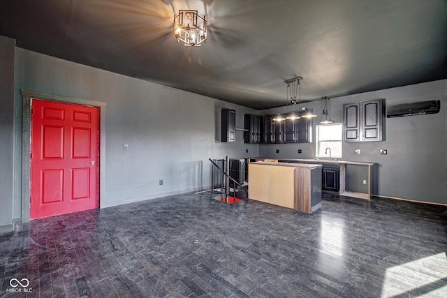 kitchen with dark wood-type flooring, a center island, a sink, and baseboards