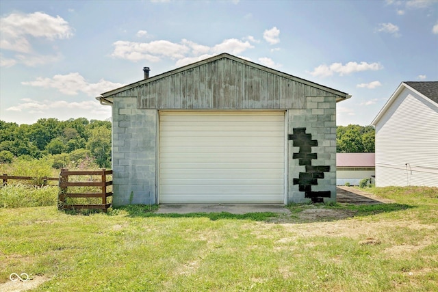 view of outbuilding featuring driveway, fence, and an outbuilding