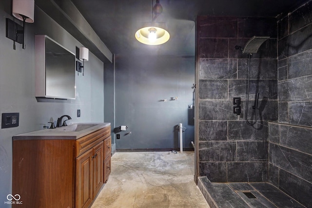 bathroom with a tile shower and vanity