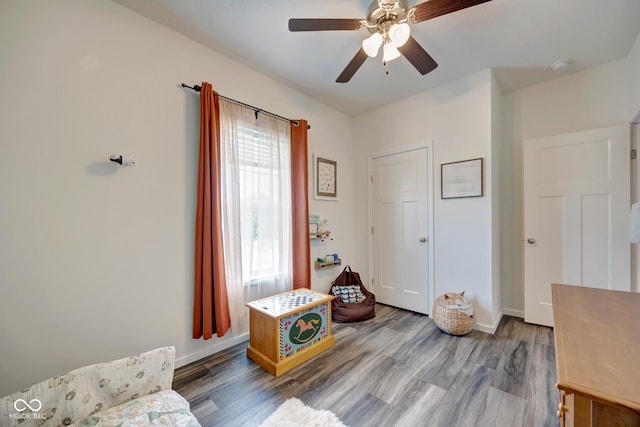 interior space featuring ceiling fan, wood finished floors, and baseboards