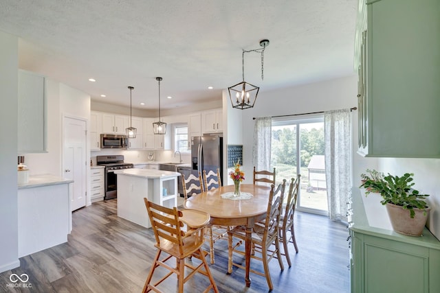 dining area with recessed lighting, a notable chandelier, plenty of natural light, and wood finished floors