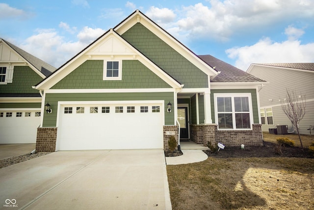 craftsman-style house with a garage, central AC unit, concrete driveway, and brick siding