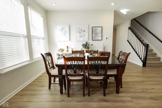 dining room with light wood-type flooring, baseboards, stairway, and recessed lighting