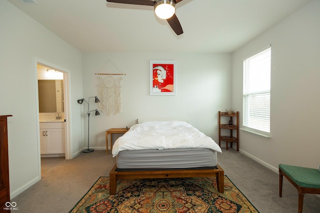 bedroom featuring light carpet, connected bathroom, baseboards, and a sink