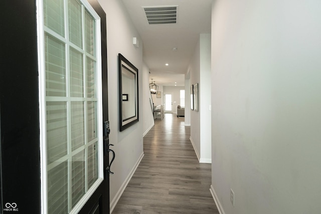 hall featuring dark wood-style flooring, recessed lighting, visible vents, and baseboards