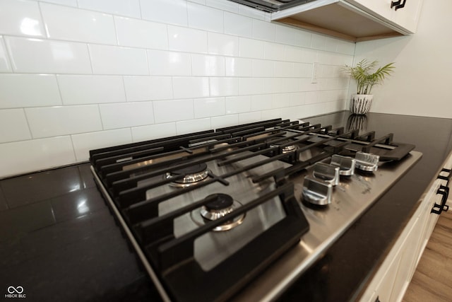 room details featuring stainless steel gas stovetop and decorative backsplash