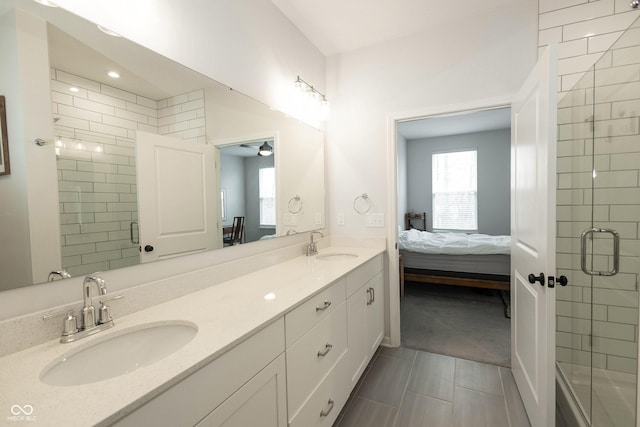 ensuite bathroom featuring double vanity, a shower stall, and a sink