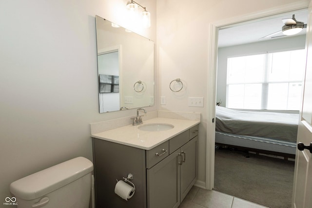 bathroom featuring tile patterned flooring, connected bathroom, vanity, and toilet