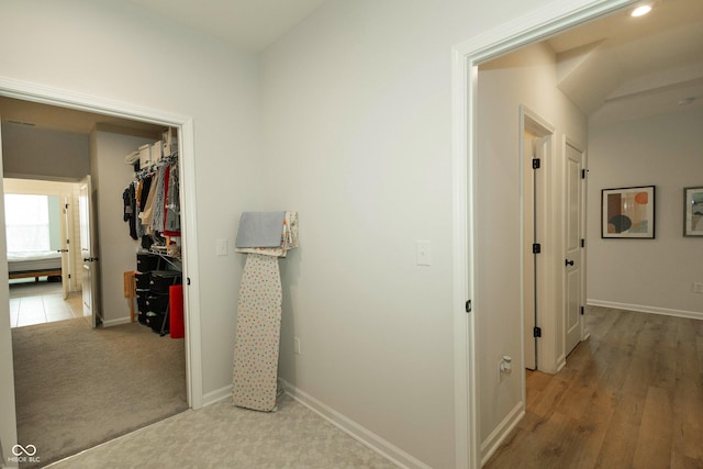 hall featuring baseboards and carpet flooring