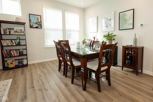 dining space featuring light wood-style floors and baseboards